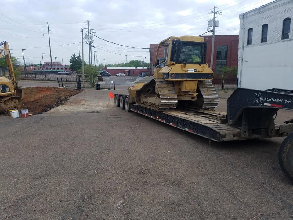 Bulldozer being loaded onto a lowboy trailer for transport between job sites