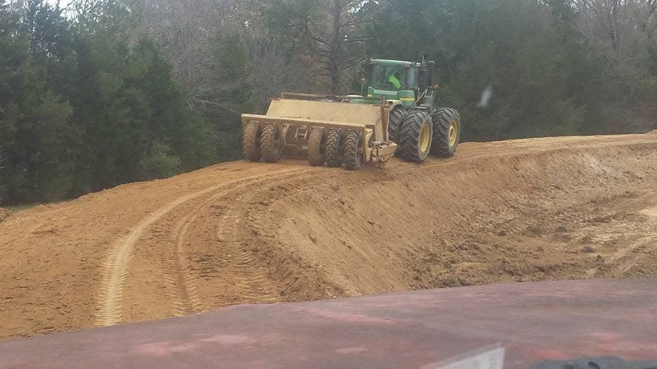 Tractor pulling a land plane along a graded ridge