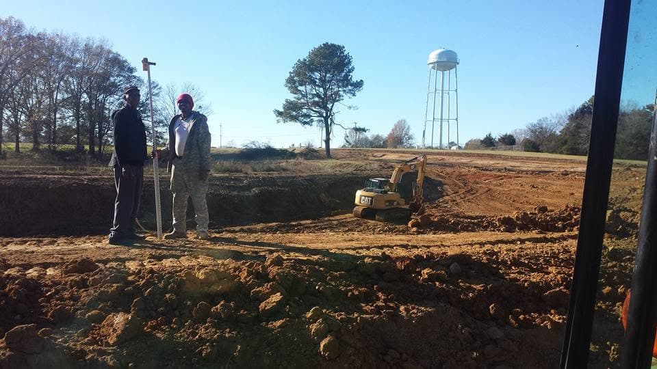 Nichols and Sons Construction crew surveying an excavation site near the Canton water tower
